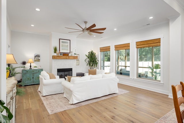 living room featuring crown molding, ceiling fan, and light hardwood / wood-style floors