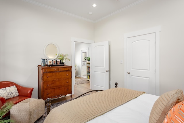 bedroom featuring crown molding and light hardwood / wood-style flooring