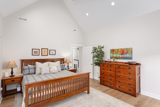 bedroom featuring high vaulted ceiling and light hardwood / wood-style flooring