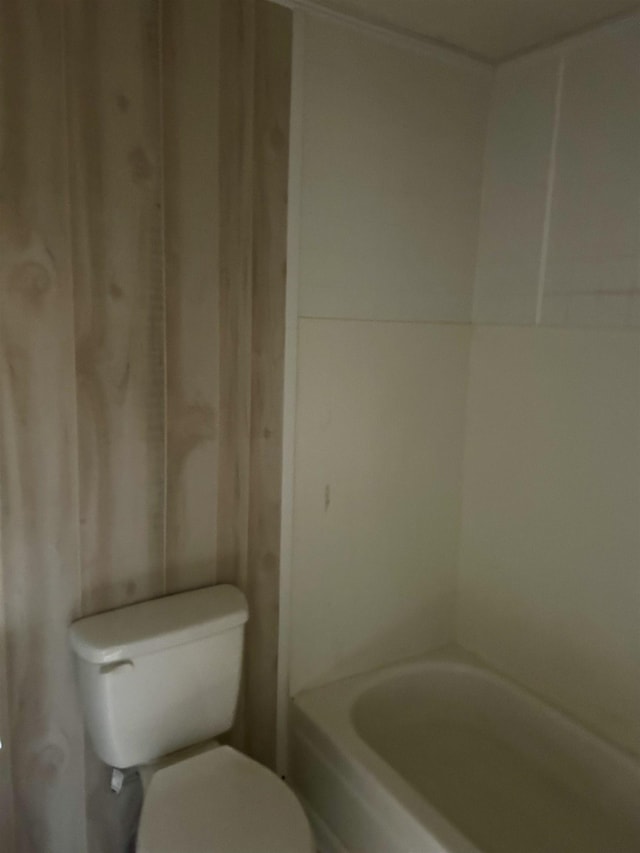 bathroom featuring toilet and a washtub