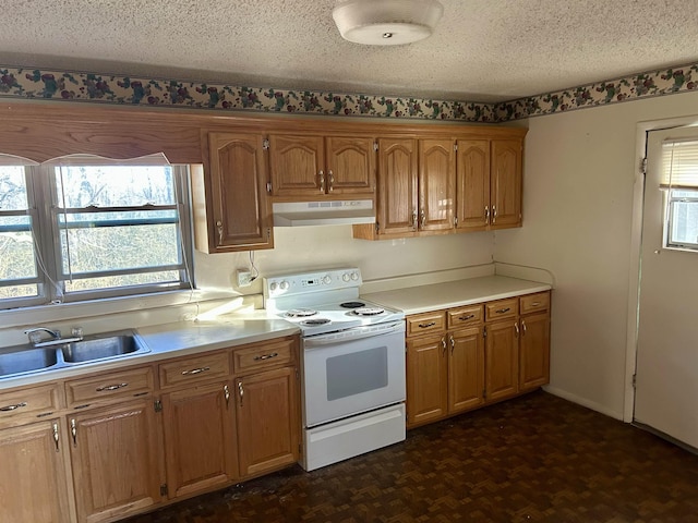 kitchen with under cabinet range hood, light countertops, white electric range oven, a textured ceiling, and a sink