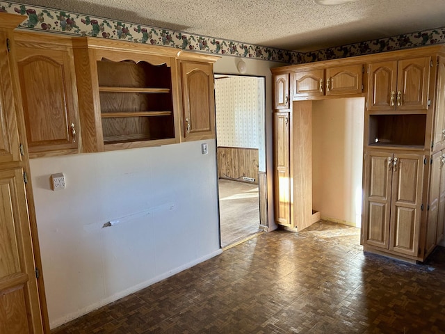 kitchen featuring a textured ceiling, baseboards, and open shelves