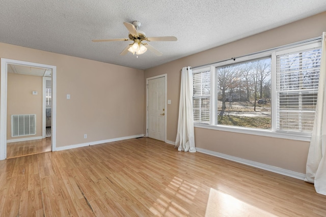 spare room featuring a textured ceiling, ceiling fan, and light hardwood / wood-style flooring