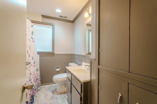 bathroom featuring toilet, vanity, and ornamental molding