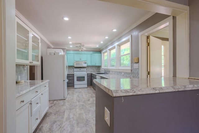 kitchen with white appliances, backsplash, sink, ceiling fan, and white cabinetry