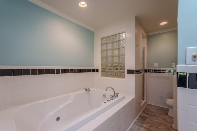 bathroom with tiled tub, ornamental molding, tile walls, and toilet