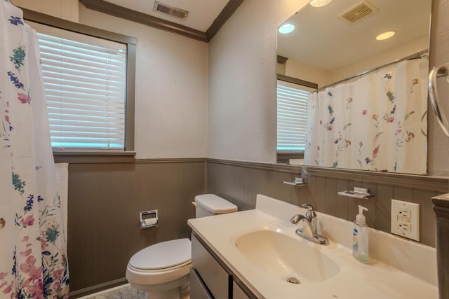 bathroom featuring vanity, crown molding, wooden walls, toilet, and walk in shower