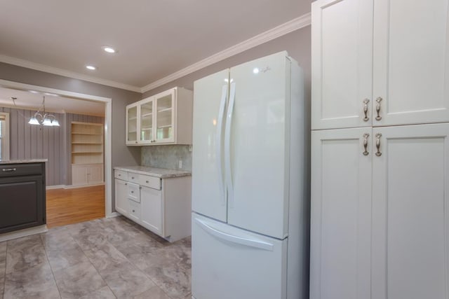 kitchen with backsplash, white fridge, white cabinetry, and crown molding