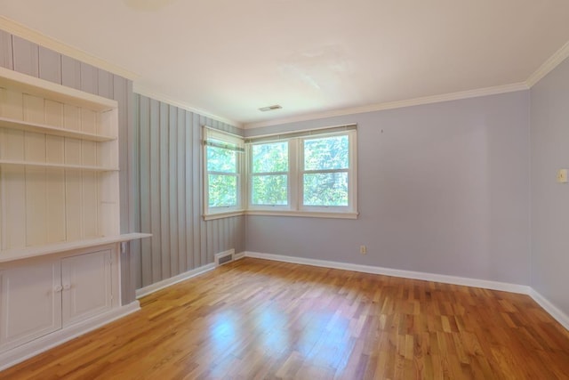 unfurnished room with built in features, light hardwood / wood-style floors, and ornamental molding