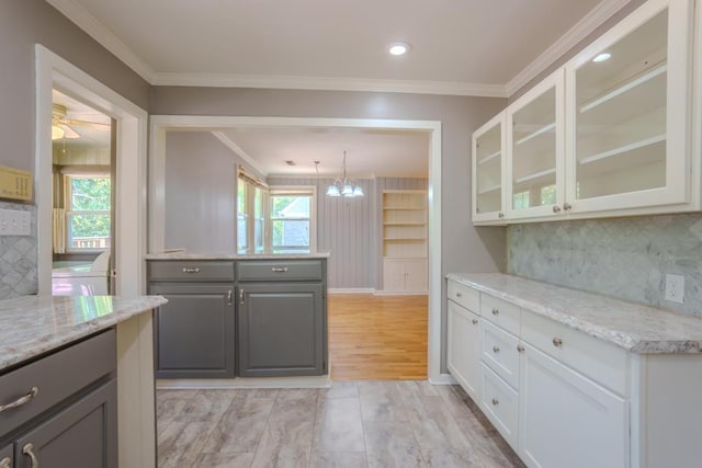 kitchen featuring gray cabinetry, white cabinetry, light stone countertops, tasteful backsplash, and pendant lighting