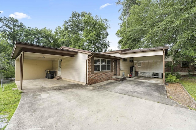  - view of front of property featuring a carport, concrete driveway, and brick siding