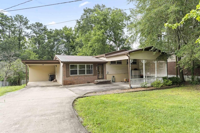 - tri-level home featuring a carport, concrete driveway, a front lawn, and brick siding