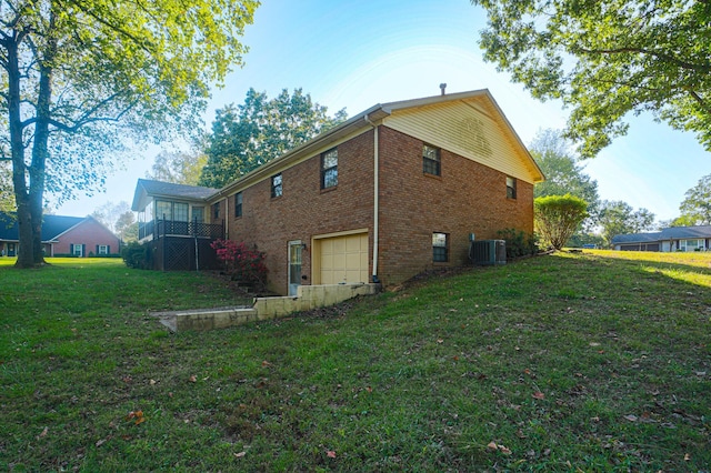 view of home's exterior featuring central air condition unit, a yard, and a garage