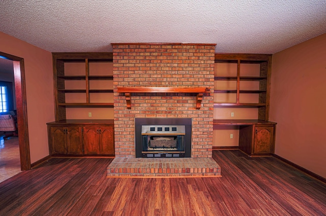 unfurnished living room featuring a fireplace, a textured ceiling, and dark wood-type flooring