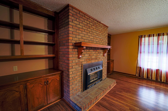 unfurnished living room with a fireplace, a textured ceiling, and dark wood-type flooring