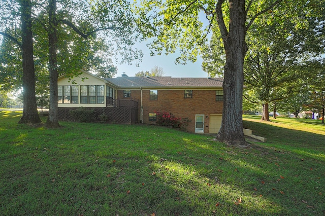 rear view of house with a garage and a lawn