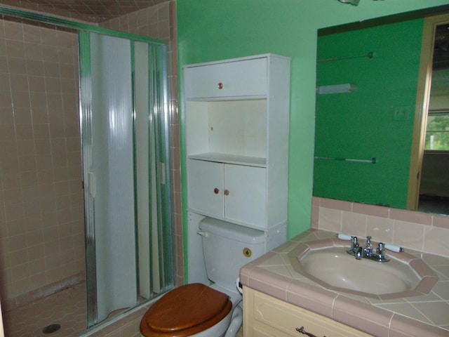 bathroom with an enclosed shower, vanity, toilet, and backsplash