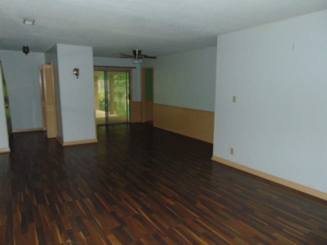 unfurnished room with ceiling fan and dark hardwood / wood-style flooring