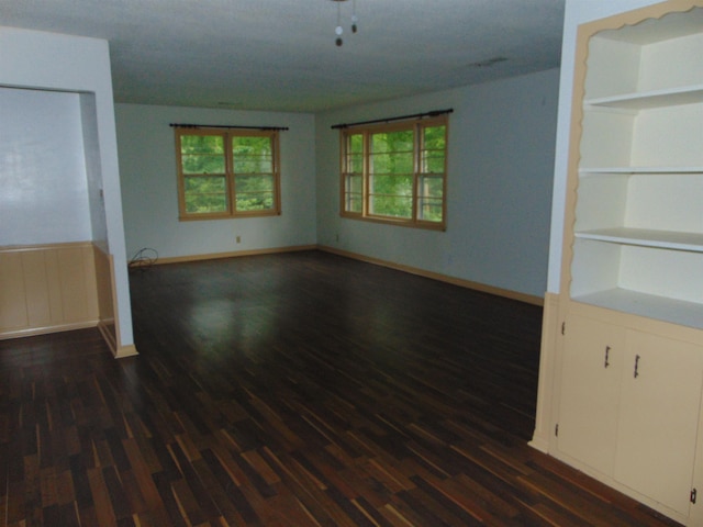 unfurnished living room with built in shelves