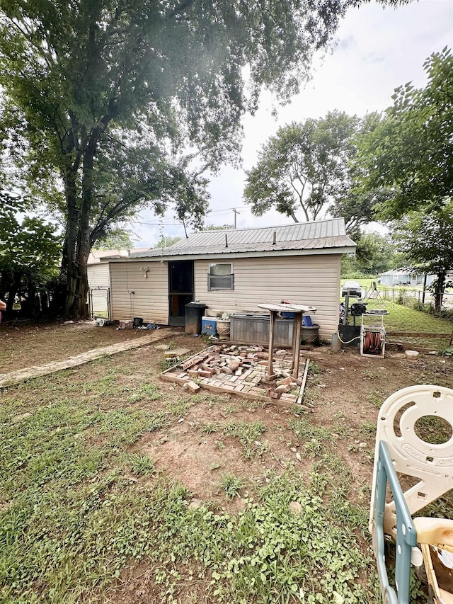  - back of house featuring a metal roof