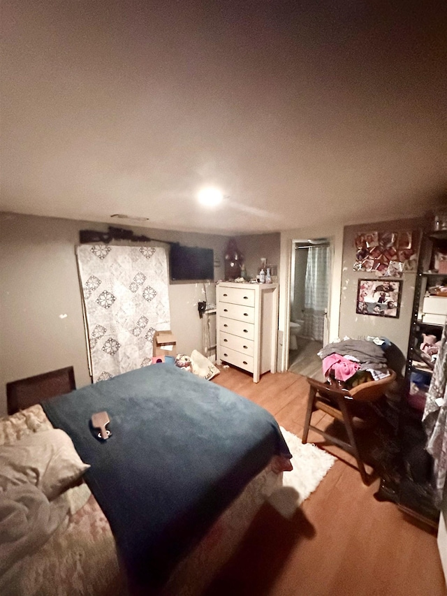  - bedroom featuring light wood-style flooring and connected bathroom