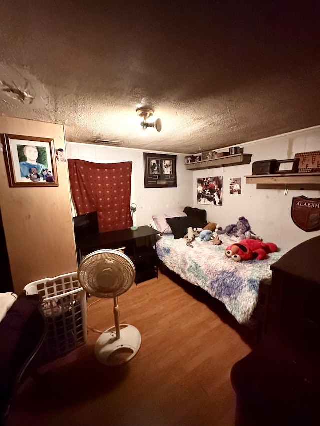  - bedroom featuring wood finished floors and a textured ceiling