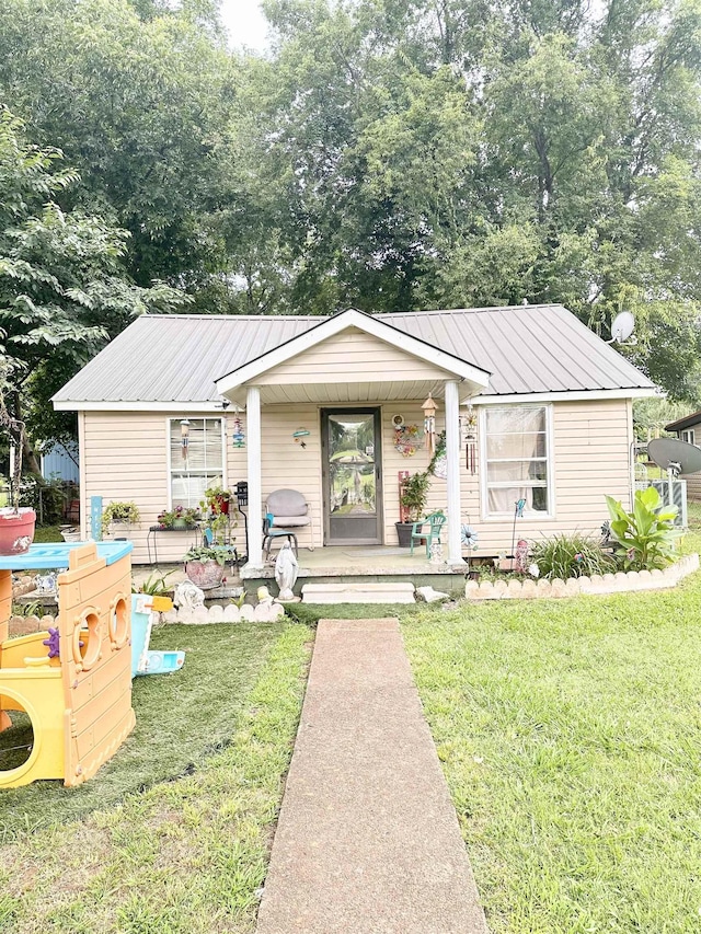  - view of front of home featuring covered porch, a front yard, and a metal roof