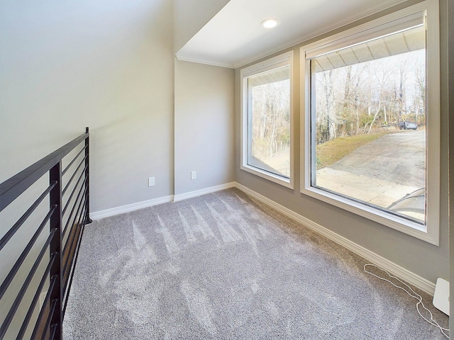 carpeted empty room with crown molding and baseboards