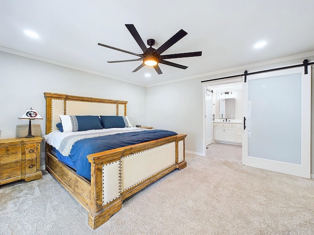 bedroom with light colored carpet, a barn door, ornamental molding, a ceiling fan, and ensuite bath