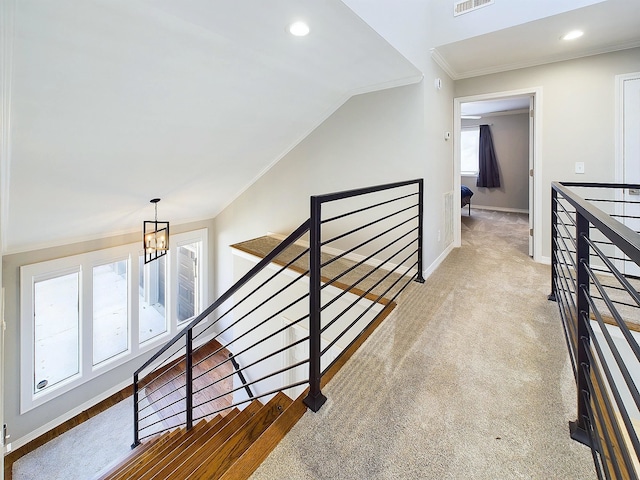 hall featuring carpet, baseboards, crown molding, and an upstairs landing