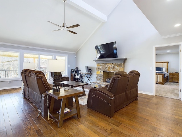 living area with a stone fireplace, baseboards, ornamental molding, beam ceiling, and hardwood / wood-style floors