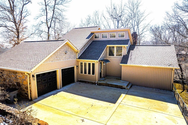 view of front of property featuring an attached garage, driveway, a chimney, and roof with shingles