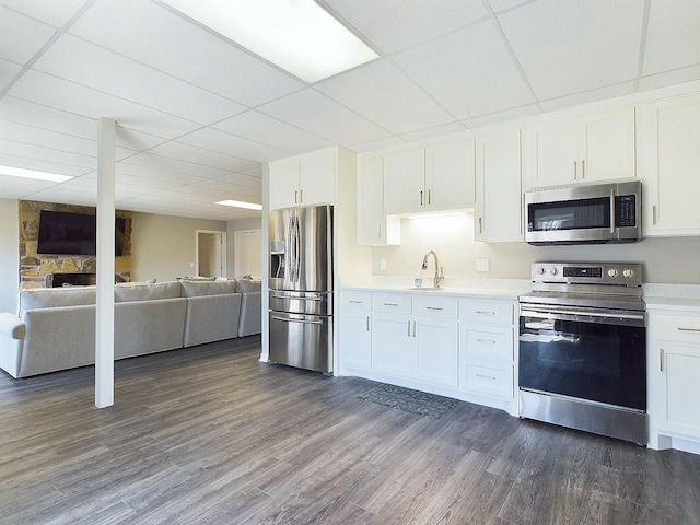 kitchen with open floor plan, light countertops, appliances with stainless steel finishes, and dark wood-type flooring