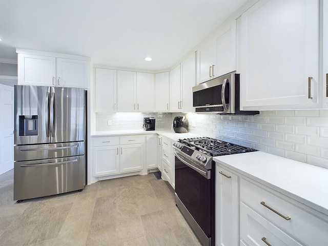 kitchen with appliances with stainless steel finishes, white cabinets, light countertops, and backsplash