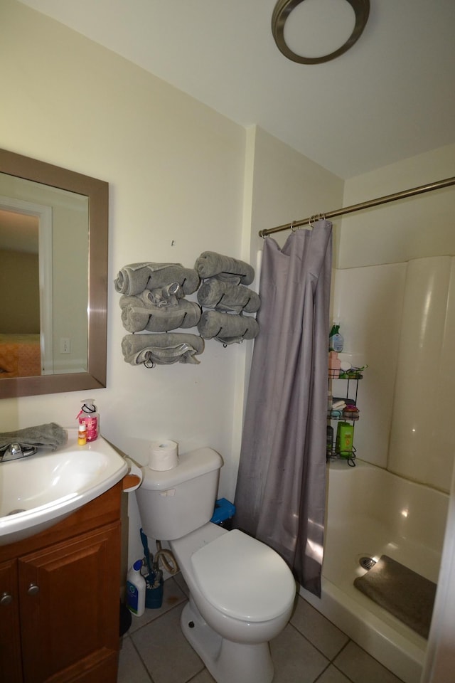 bathroom featuring tile patterned flooring, vanity, curtained shower, and toilet