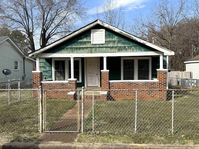 bungalow with covered porch and a front lawn