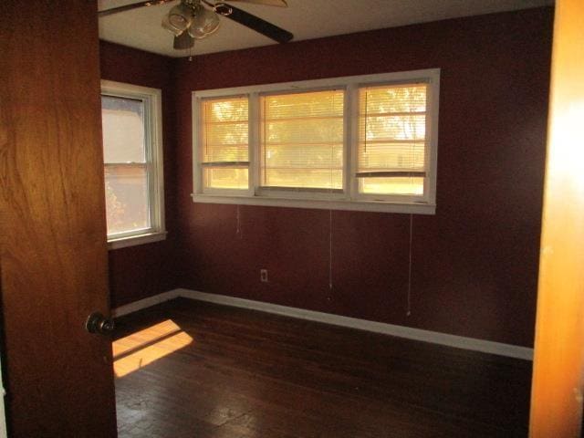 empty room with ceiling fan and dark hardwood / wood-style flooring