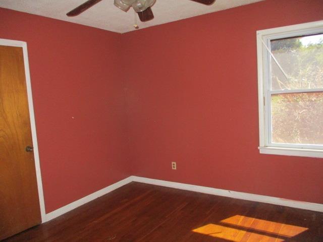 unfurnished room with a wealth of natural light and dark wood-type flooring