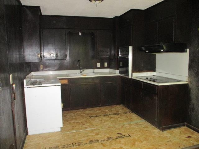 kitchen featuring ventilation hood, sink, black oven, dark brown cabinets, and electric stovetop