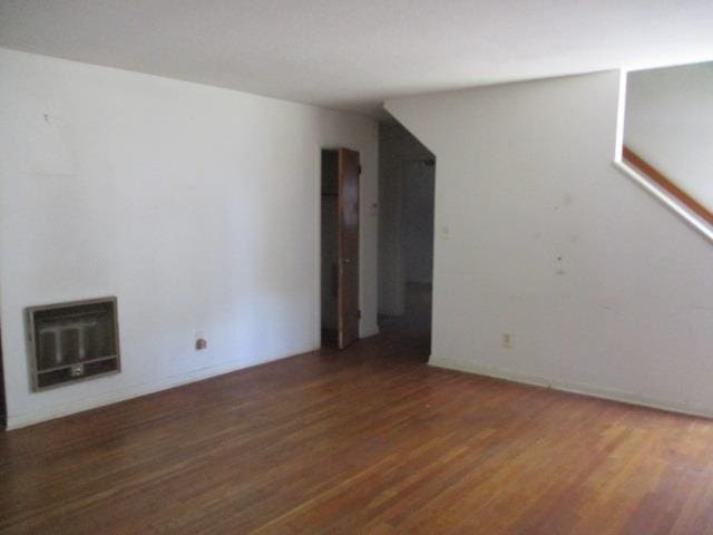 unfurnished room with dark hardwood / wood-style floors and heating unit