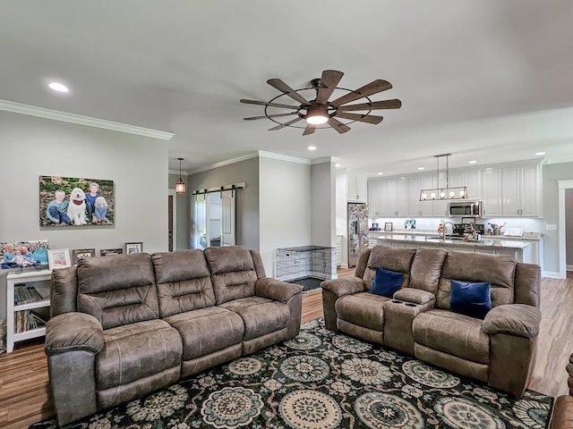 living room with light hardwood / wood-style floors, ceiling fan, and ornamental molding