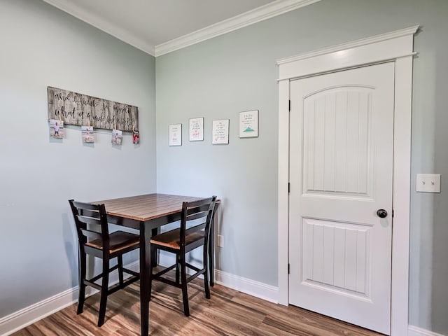 dining area with hardwood / wood-style flooring and ornamental molding