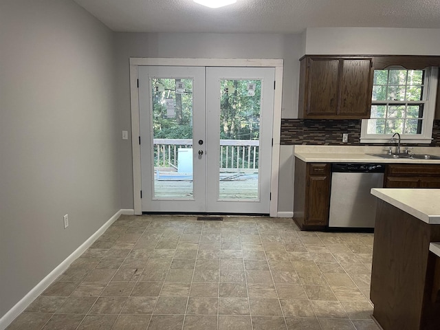  - kitchen featuring stainless steel dishwasher, a sink, healthy amount of natural light, and light countertops
