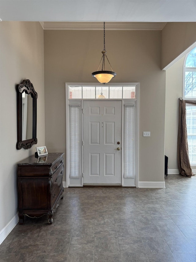 foyer entrance with baseboards and ornamental molding