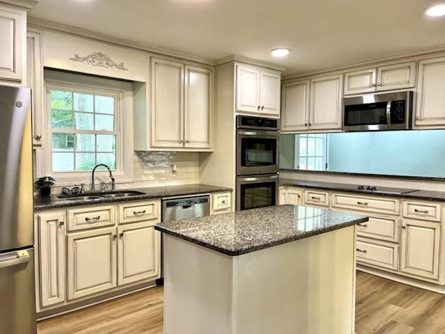  - kitchen featuring stainless steel appliances, light wood-style floors, dark stone counters, backsplash, and recessed lighting