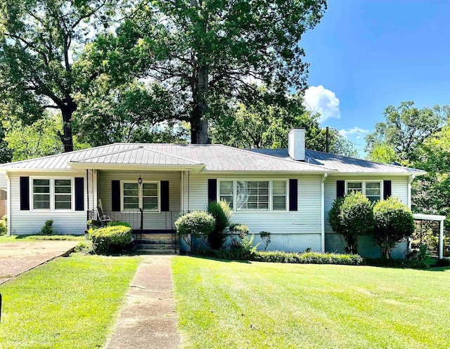  - ranch-style house featuring a porch, a front yard, a metal roof, and a chimney