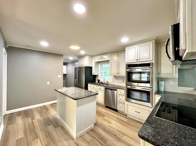  - kitchen with stainless steel appliances, light wood finished floors, a center island, tasteful backsplash, and recessed lighting