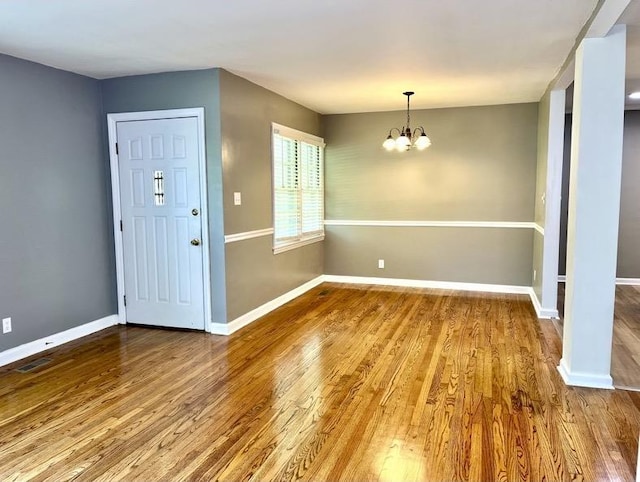  - entryway featuring wood finished floors and a chandelier