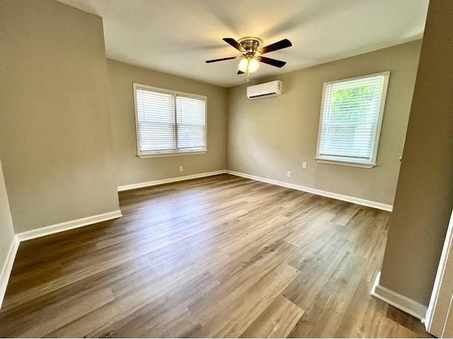  - empty room featuring a wall unit AC, dark wood-style floors, and ceiling fan