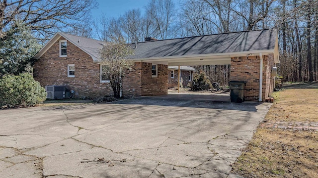 view of side of property featuring central AC and a carport